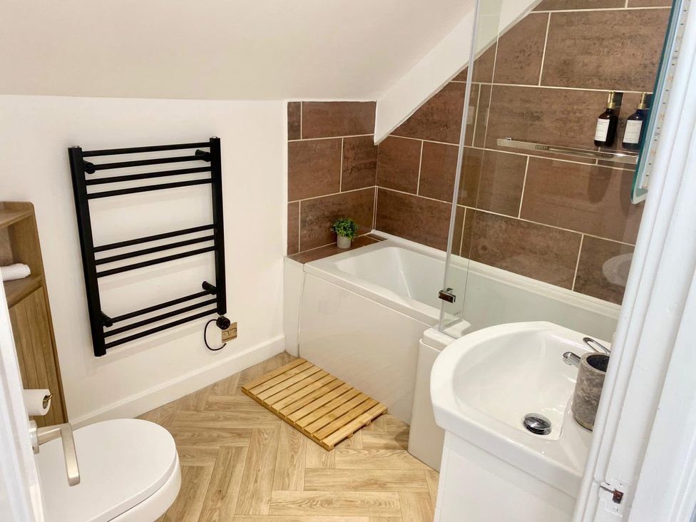 A bathroom featuring a bath tub, shower, sink, and towel rail at Central Tenby 3 Bed Apt Sleeps 6 to 8 Dog Friendly, Tenby