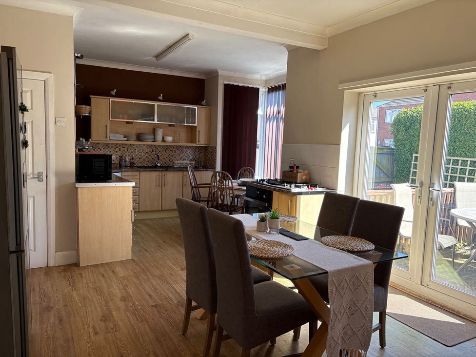 A kitchen with dining table and chairs at 5 Bed Villa Sleeps 10 Pets Garden Parking Skegness