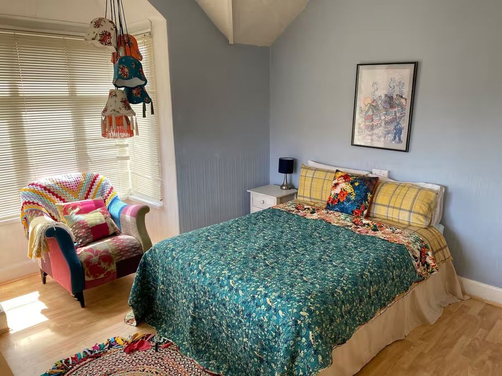 A bedroom with a bed and armchair at 5 Bed Villa Sleeps 10 Pets Garden Parking in Skegness