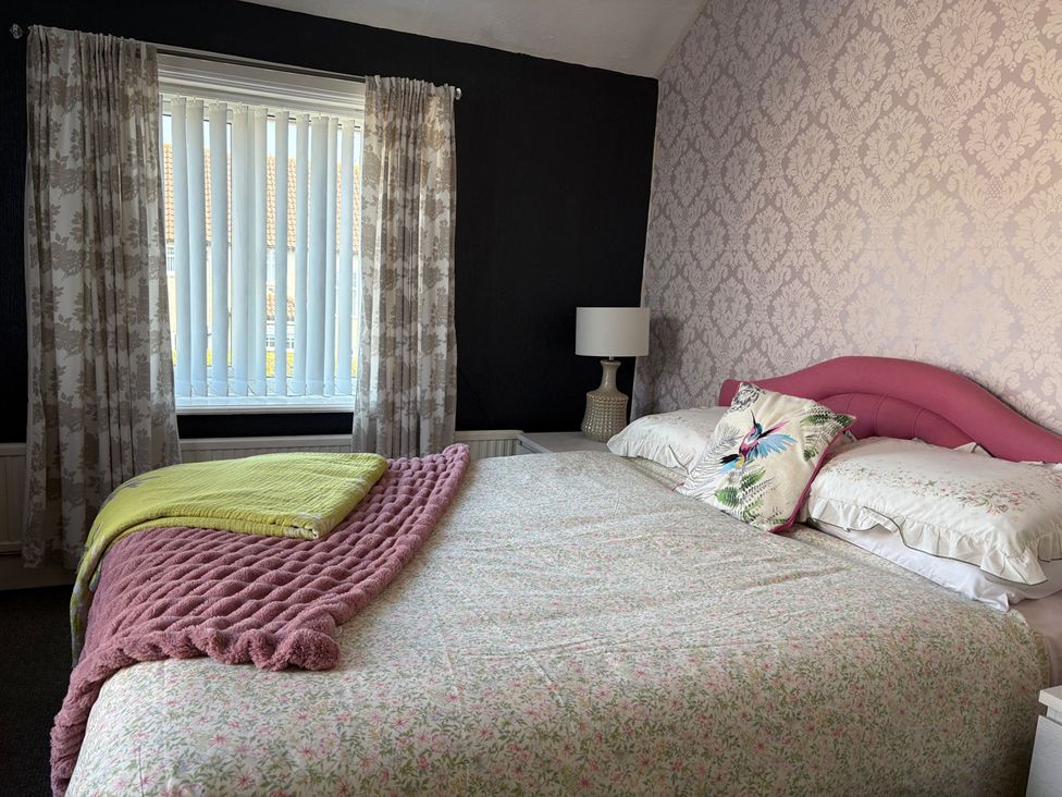 A bedroom with a bed and a window at 5 Bed Villa Sleeps 10 Pets Garden Parking Skegness