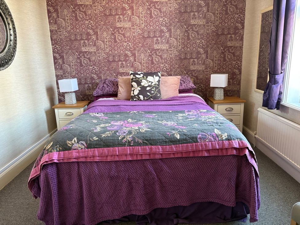 A bedroom with a bed and nightstands at 5 Bed Villa Sleeps 10 Pets Garden Parking Skegness