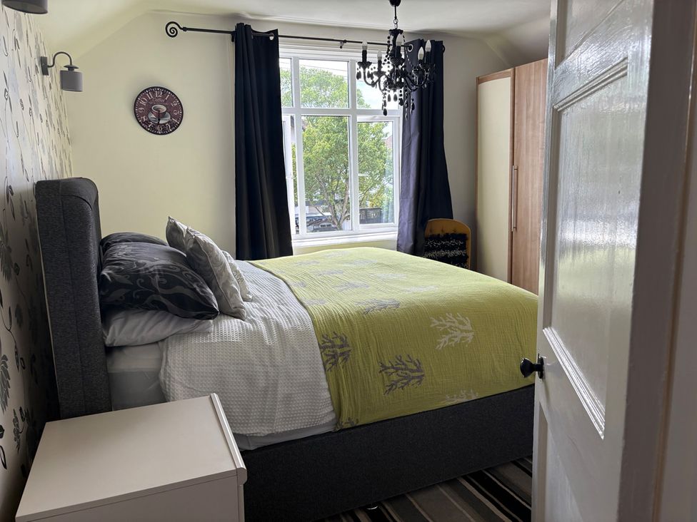 A bedroom with a bed and window at 5 Bed Villa Sleeps 10 Pets Garden Parking Skegness