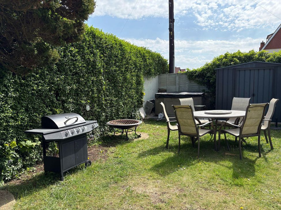 A garden with a barbecue grill and dining area at 5 Bed Villa Sleeps 10 Pets Garden Parking Skegness