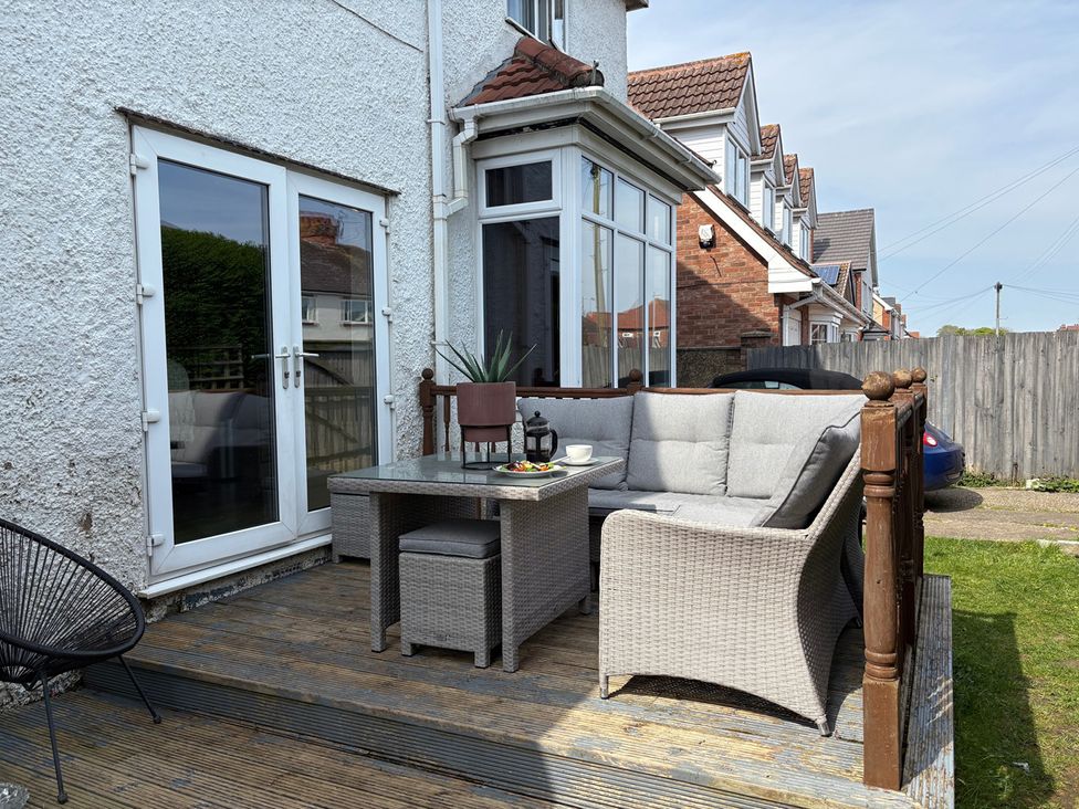 An outdoor seating area with a table and sofa at 5 Bed Villa Sleeps 10 Pets Garden Parking in Skegness