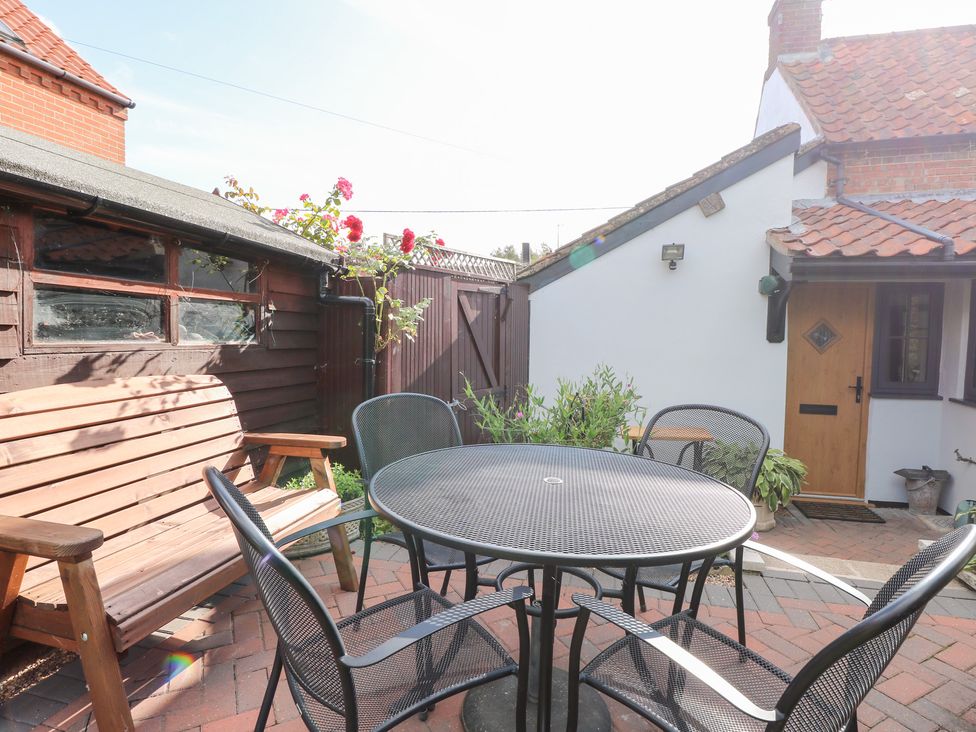 A garden with a table and chairs at Hollyhedge Cottage in Briston