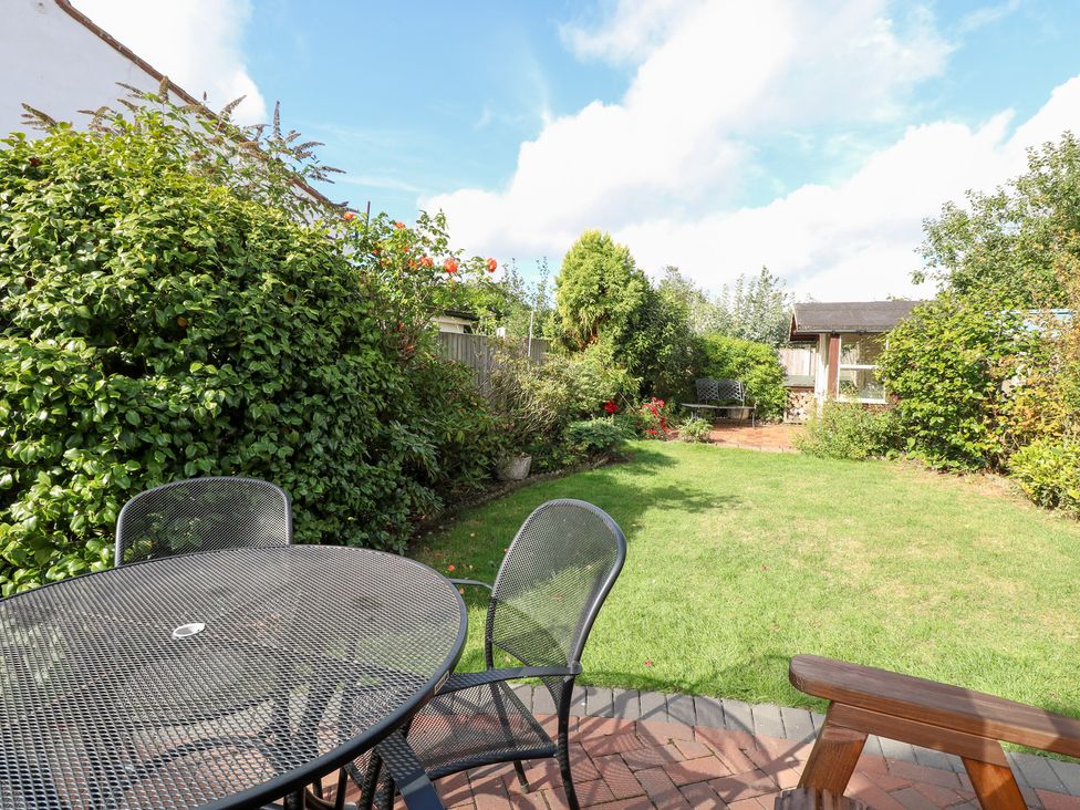 A garden with a table and chairs at Hollyhedge Cottage in Briston