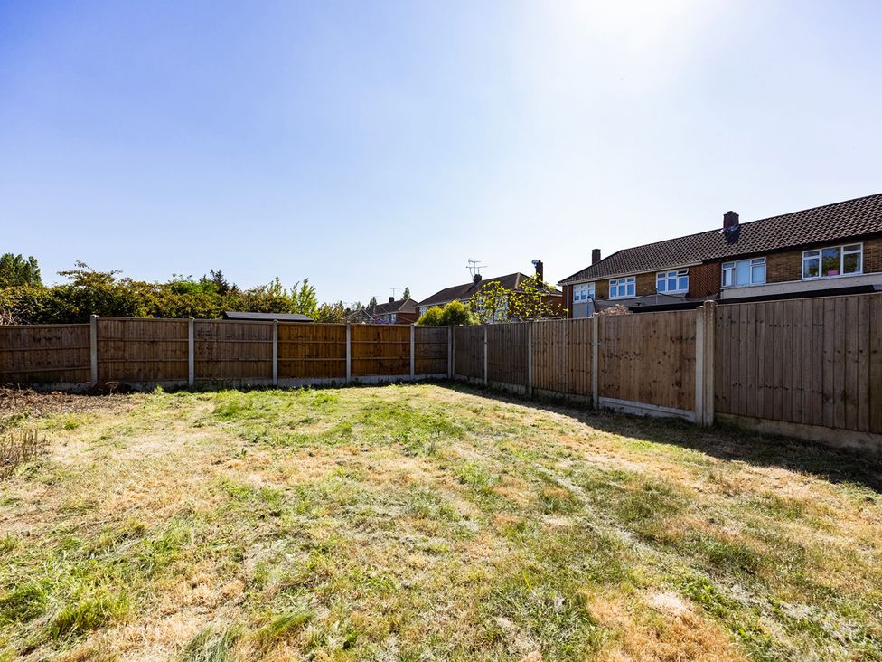 A garden with grass and fences at House Sleeps 14 with Parking and Garden East Tilbury