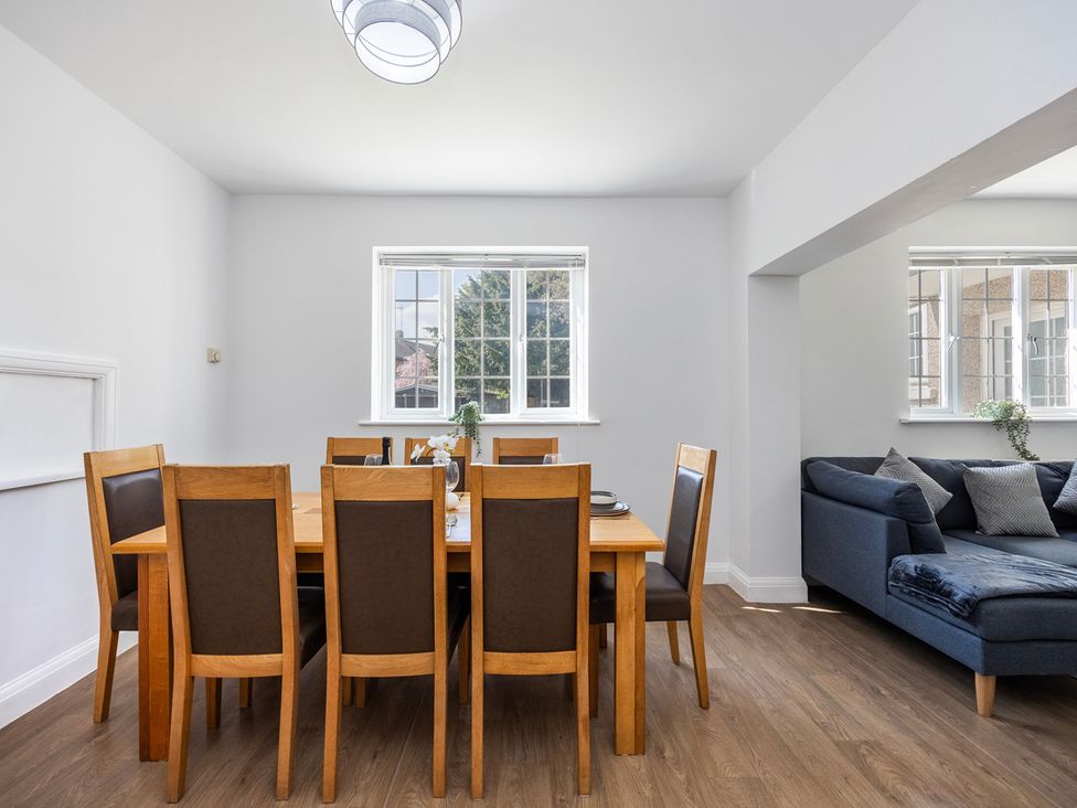 A dining room with a table and chairs at House Sleeps 14 with Parking and Garden in East Tilbury