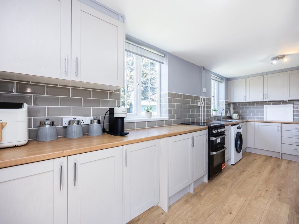 A kitchen with cabinets and appliances at House Sleeps 14 with Parking and Garden in East Tilbury