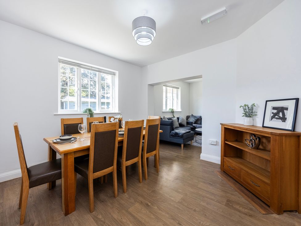 A dining room with a table and chairs at House Sleeps 14 with Parking and Garden in East Tilbury