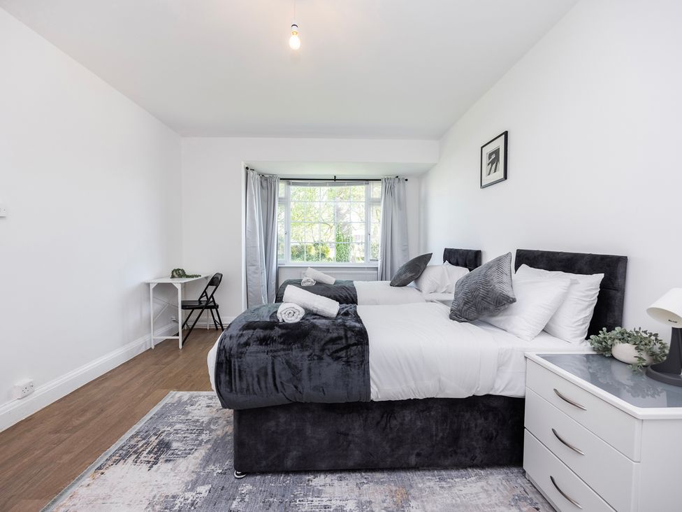 A bedroom with two beds and a desk at House Sleeps 14 with Parking and Garden East Tilbury