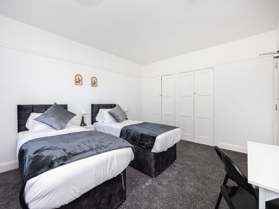 A bedroom with two beds and a desk at House Sleeps 14 with Parking and Garden in East Tilbury