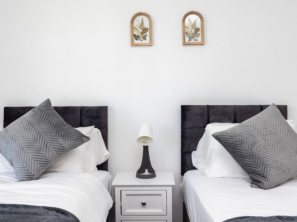 A bedroom with two beds and nightstands at House Sleeps 14 with Parking and Garden East Tilbury