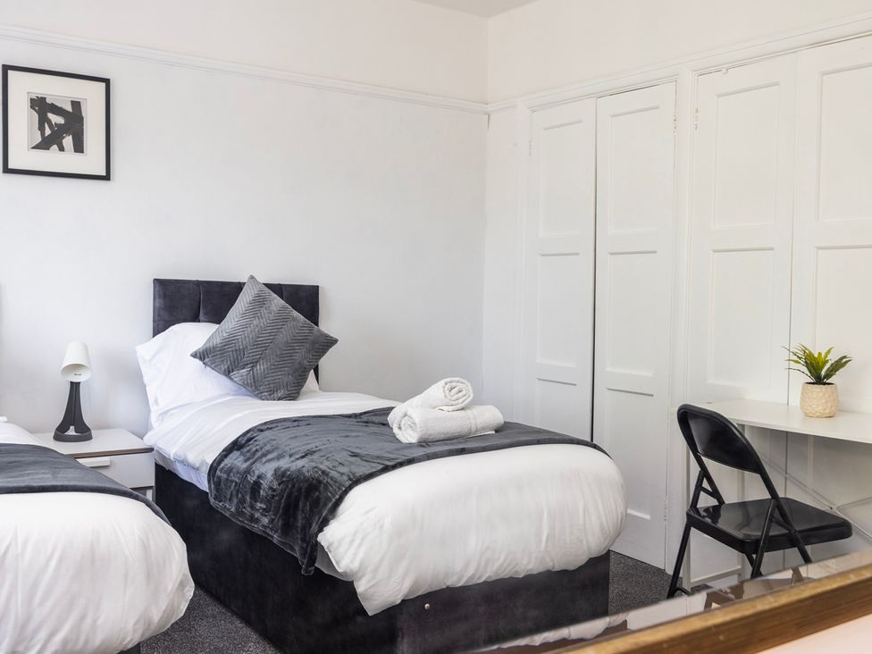 A bedroom with two beds and a desk at House Sleeps 14 with Parking and Garden East Tilbury
