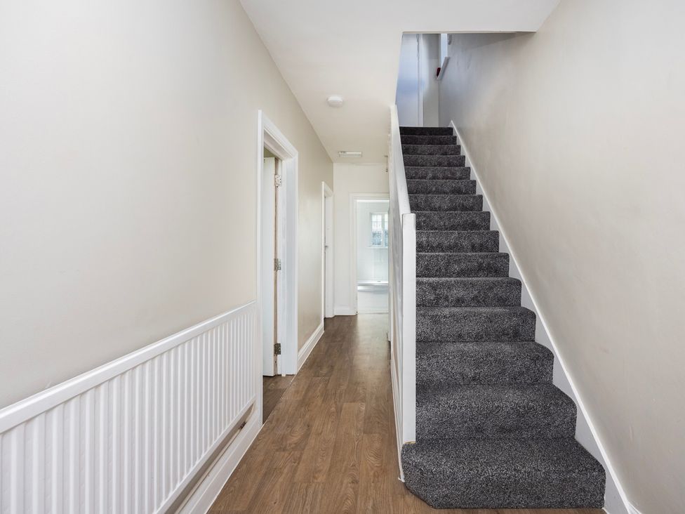A hallway with stairs and doors at House Sleeps 14 with Parking and Garden East Tilbury