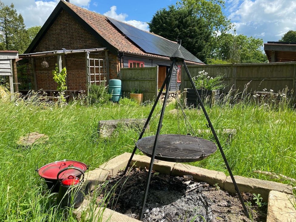 A garden with grill, fire pit and storage containers at Pet Friendly 3Bed Barn Sleeps 7 Parking Garden in Westhall near Halesworth