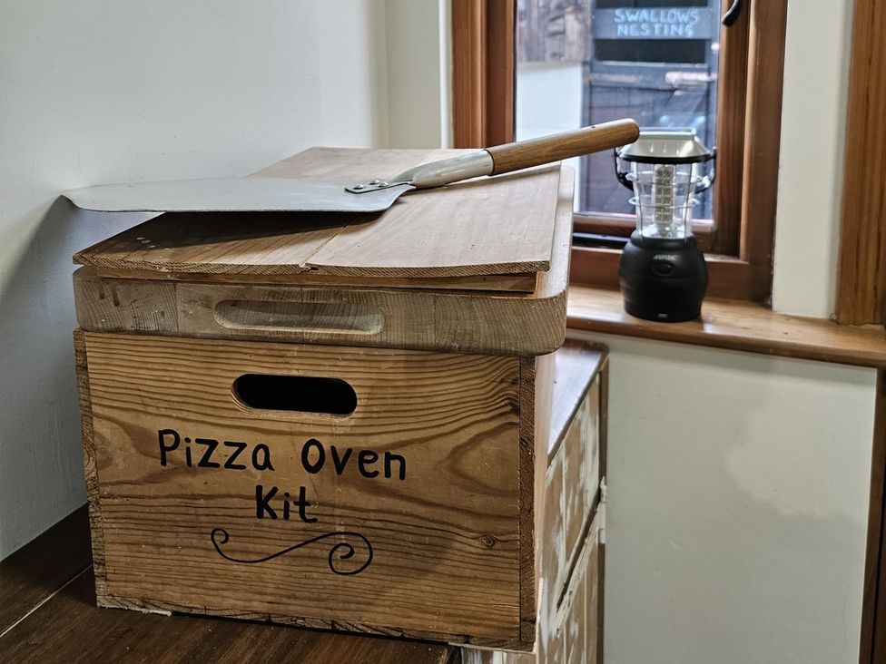 A pizza oven kit box with a pizza peel and lantern at Pet Friendly 3Bed Barn Sleeps 7 Parking Garden in Westhall near Halesworth
