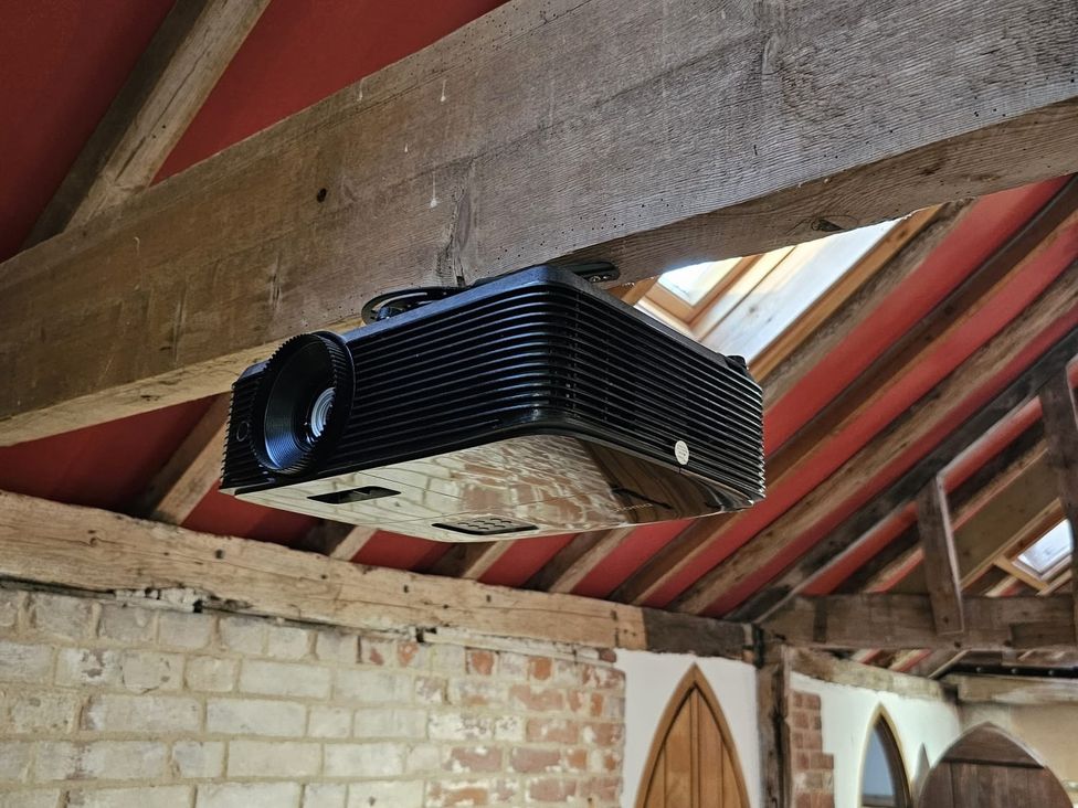 A projector mounted on wooden beams in a room at Pet Friendly 3Bed Barn Sleeps 7 Parking Garden Westhall near Halesworth