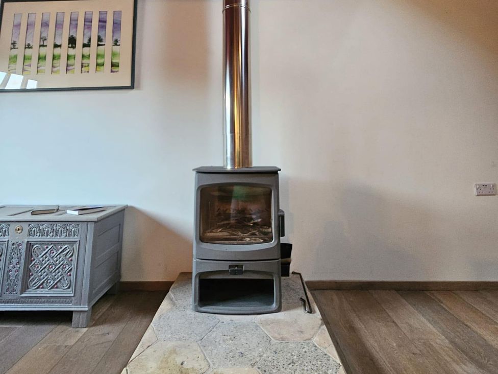 A living room with a wood stove and artwork at Pet Friendly 3Bed Barn Sleeps 7 Parking Garden in Westhall near Halesworth