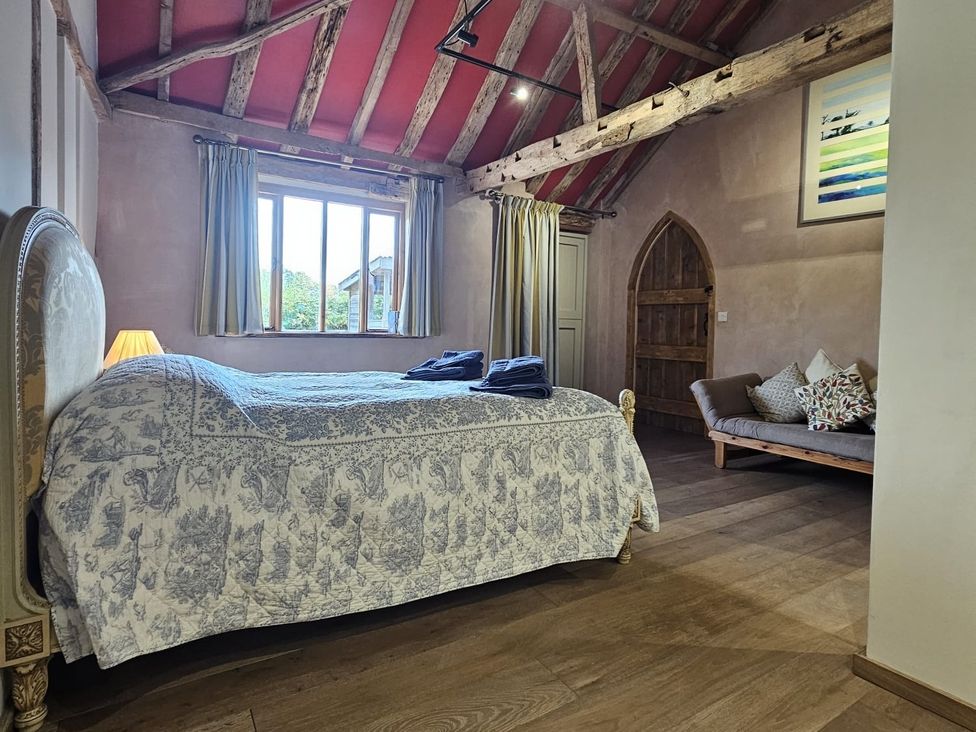A bedroom with a bed and sofa at Pet Friendly 3Bed Barn Sleeps 7 Parking Garden in Westhall near Halesworth