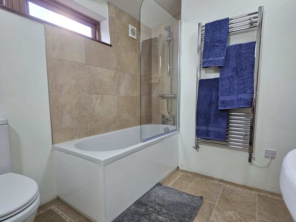 A bathroom with a bath tub and a towel rack at Pet Friendly 3Bed Barn Sleeps 7 Parking Garden Westhall near Halesworth