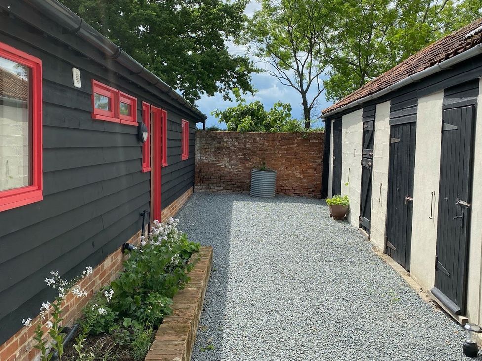 An outdoor area with gravel surface and storage sheds at Pet Friendly 3Bed Barn Sleeps 7 Parking Garden in Westhall near Halesworth