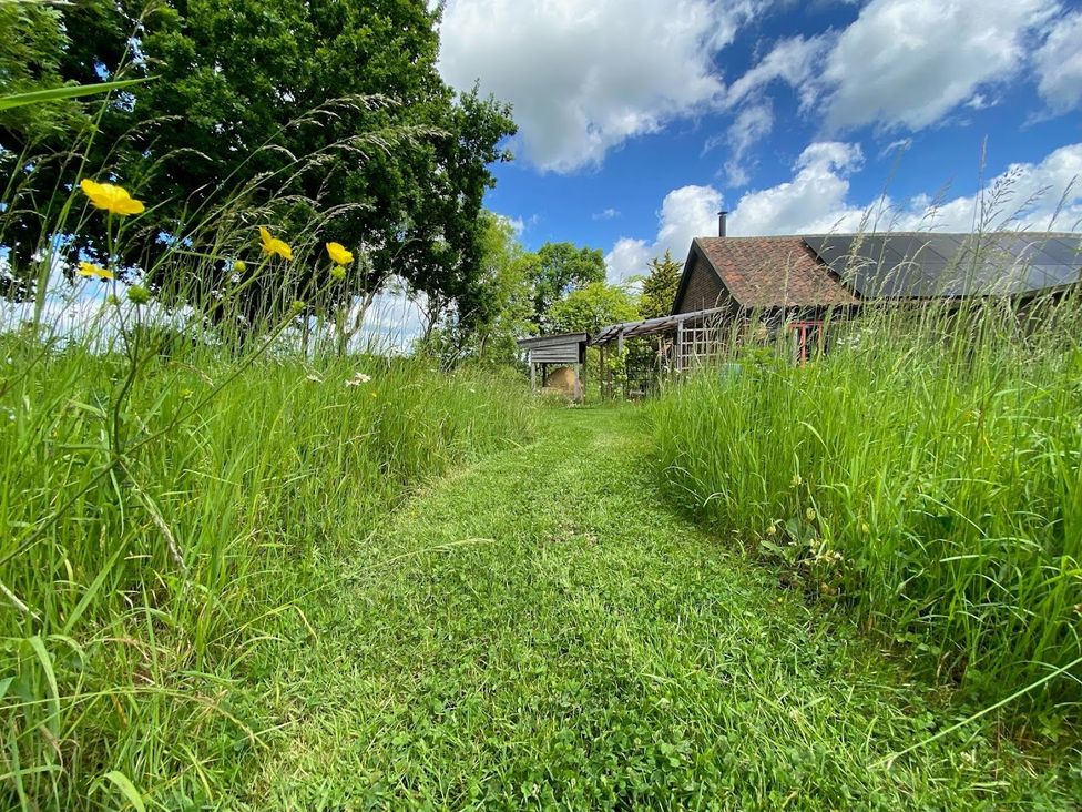 A pathway in a garden with flowers and a barn at Pet Friendly 3Bed Barn Sleeps 7 Parking Garden Westhall near Halesworth