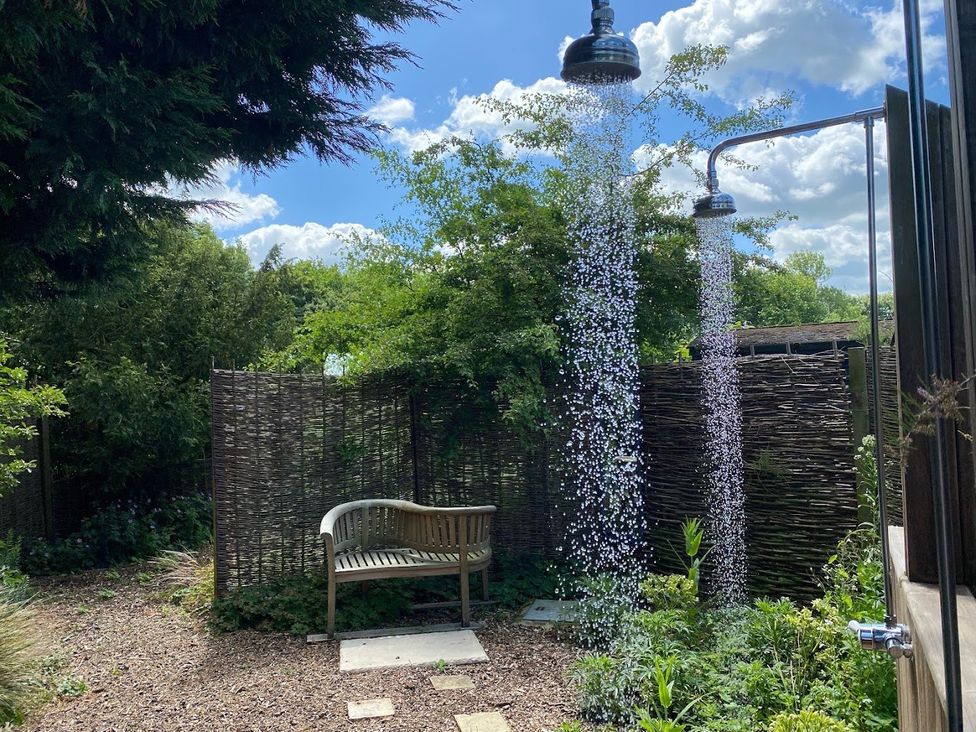 An outdoor shower with a wooden bench in the garden at Pet Friendly 3Bed Barn Sleeps 7 Parking Garden Westhall near Halesworth