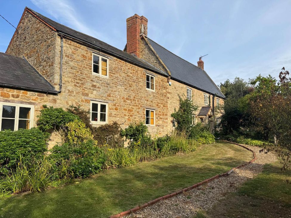 An outdoor view of a house with a garden at 17th Century Farmhouse Near Silverstone Circuit Tiffield