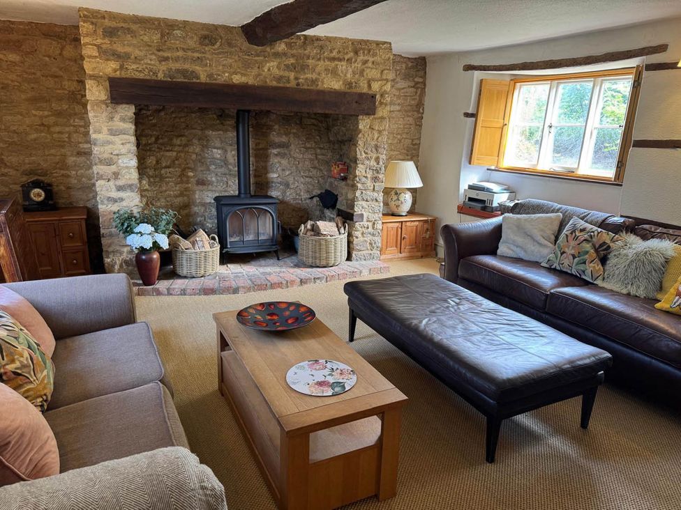 A living room with a fireplace and seating area at 17th Century Farmhouse Near Silverstone Circuit in Tiffield