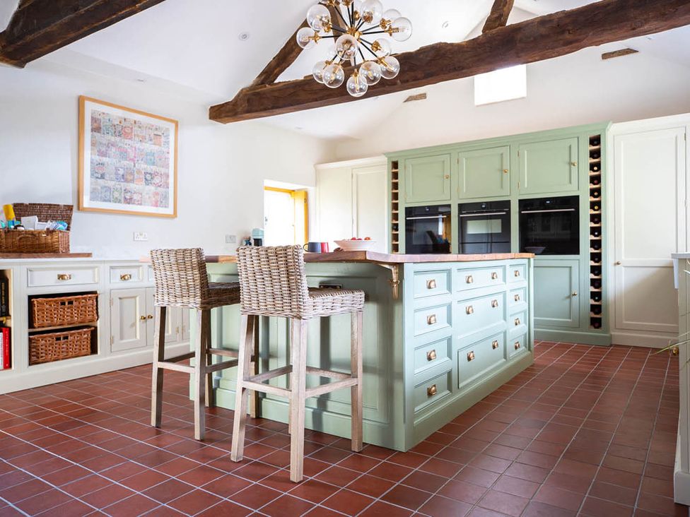 A kitchen featuring a large island and wall cabinets at 17th Century Farmhouse Near Silverstone Circuit Tiffield