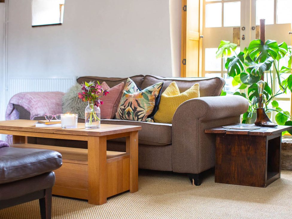 A living room with a sofa and coffee table at 17th Century Farmhouse Near Silverstone Circuit Tiffield
