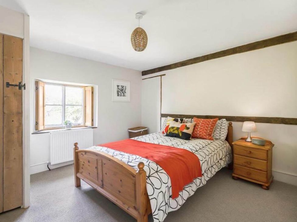 A bedroom with a bed and bedside table at 17th Century Farmhouse Near Silverstone Circuit Tiffield