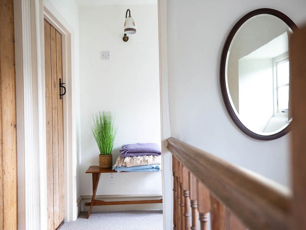 A hallway with a table, towels, and a plant at 17th Century Farmhouse Near Silverstone Circuit, Tiffield