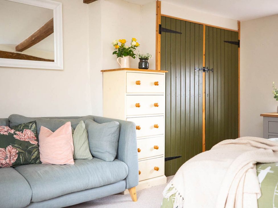 A bedroom with a sofa and chest of drawers at 17th Century Farmhouse Near Silverstone Circuit in Tiffield