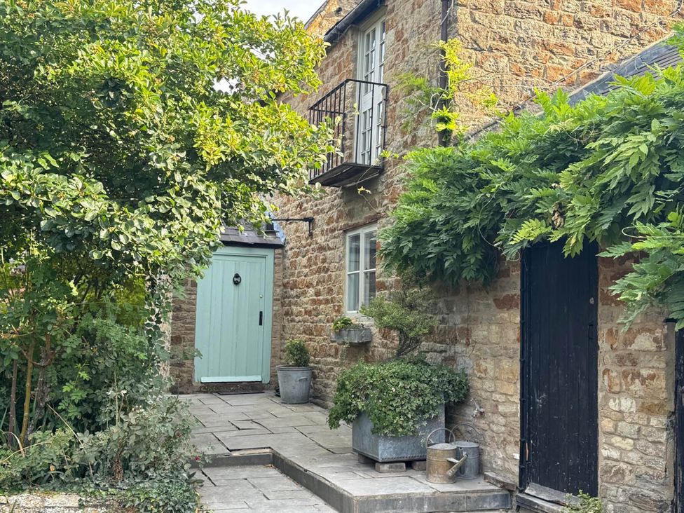 An outdoor view of a house with green and black doors at 17th Century Farmhouse Near Silverstone Circuit Tiffield