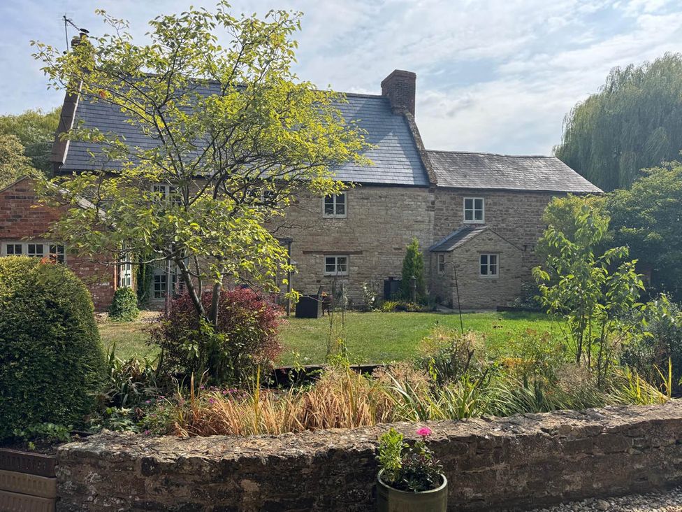 A house with garden and trees at 17th Century Farmhouse Near Silverstone Circuit Tiffield