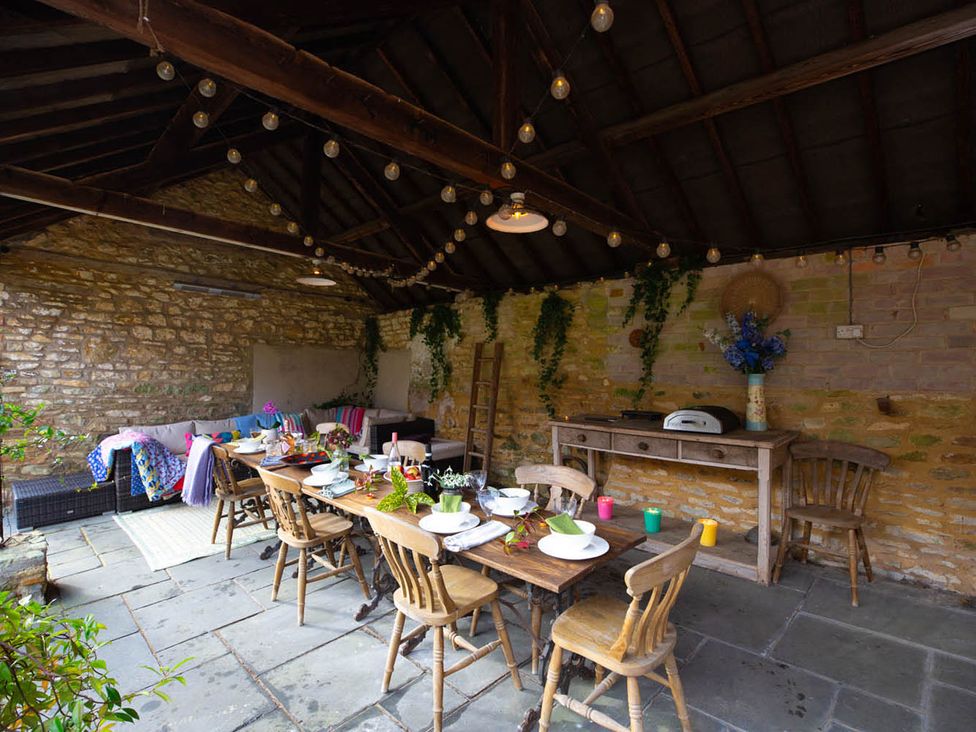 An outdoor dining area with table and chairs at 17th Century Farmhouse Near Silverstone Circuit Tiffield