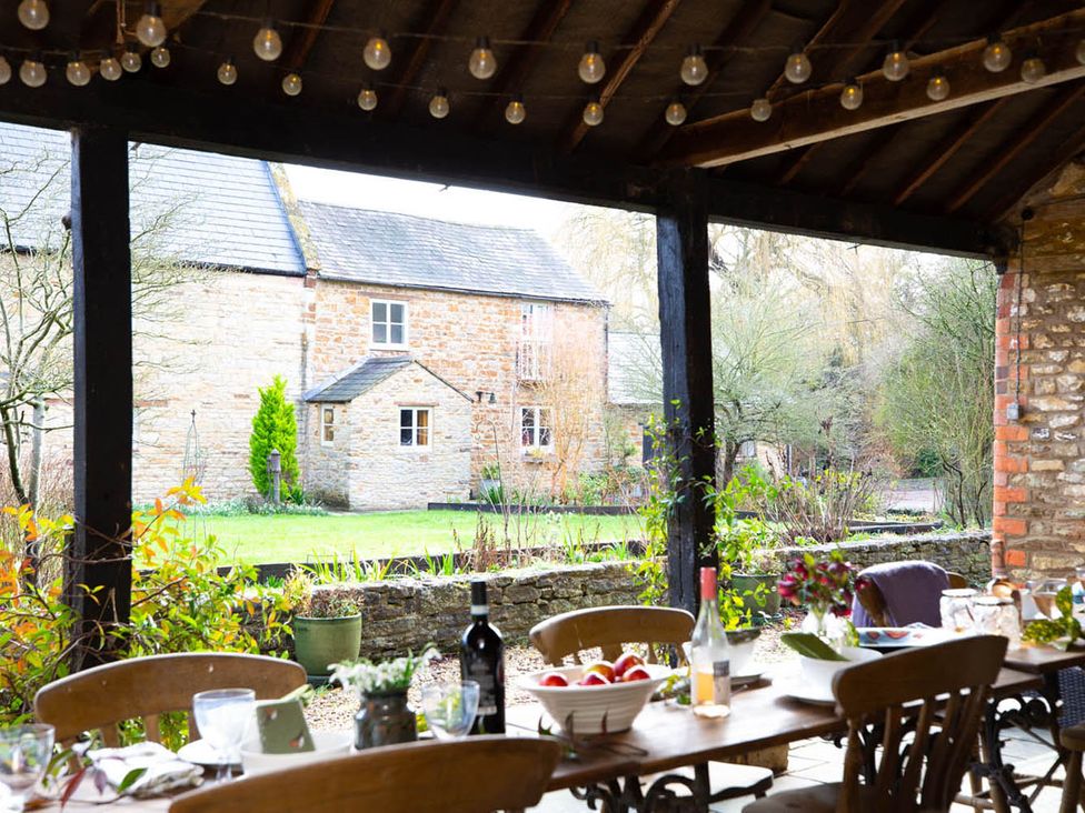 An outdoor dining area with a table and chairs at 17th Century Farmhouse Near Silverstone Circuit, Tiffield