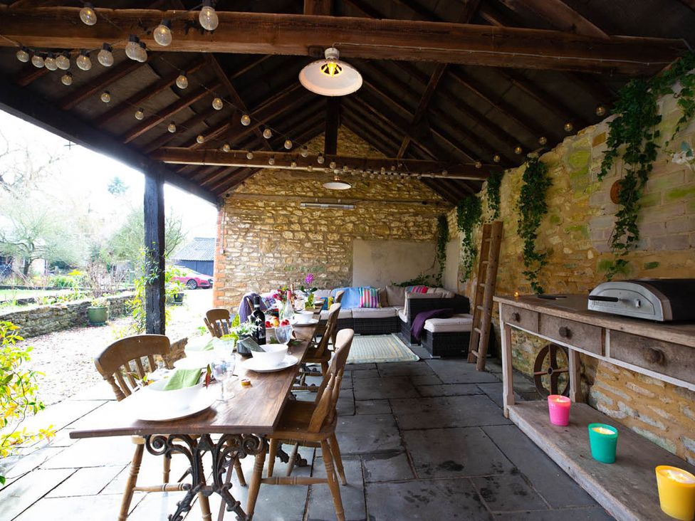 An outdoor dining area with a table and chairs at 17th Century Farmhouse Near Silverstone Circuit, Tiffield
