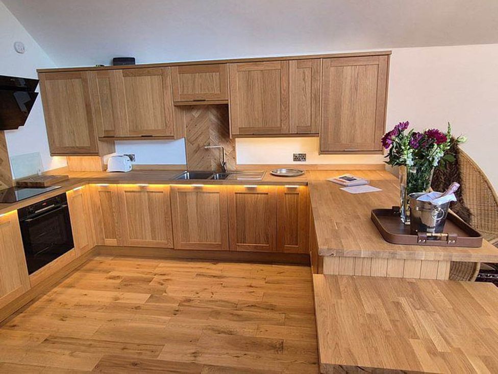 A kitchen with wooden cabinets and a sink at Sleeps6 3Bed Ayrshire Coast Near Beach Prestwick