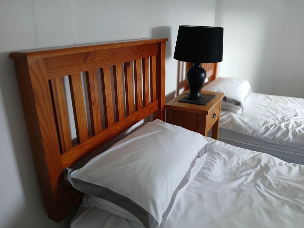 A bedroom with wooden beds and a bedside table at Sleeps6 3Bed Ayrshire Coast Near Beach Prestwick