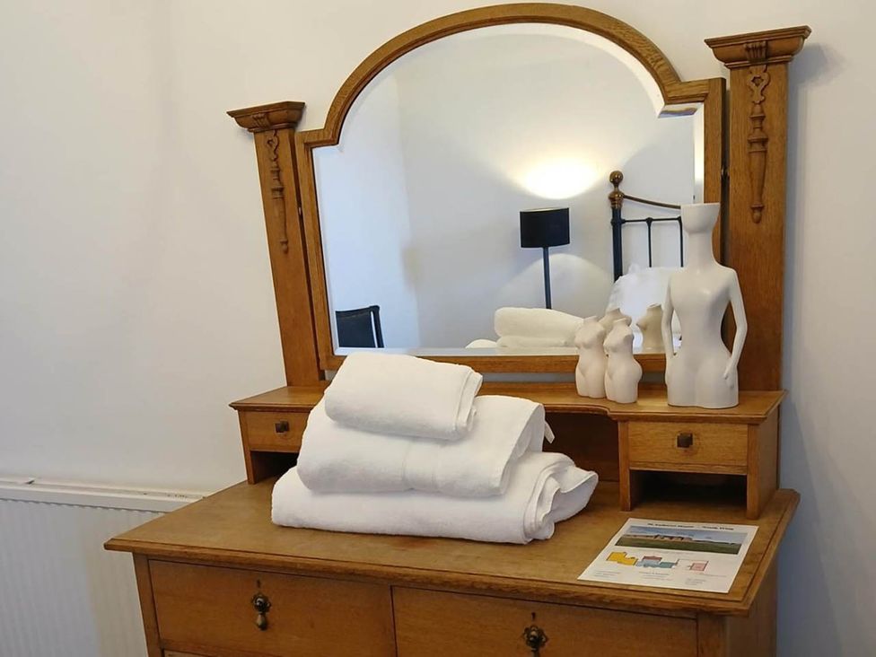 A dresser with towels and figurines at Sleeps6 3Bed Ayrshire Coast Near Beach, Prestwick