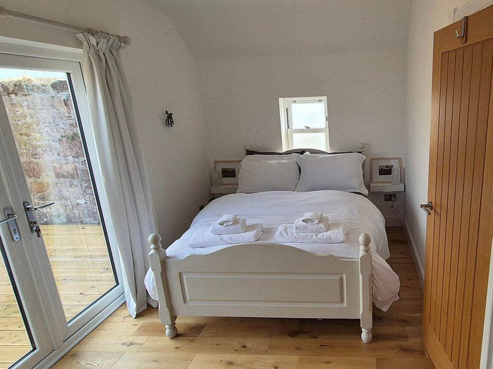 A bedroom with a bed and nightstand at Sleeps6 3Bed Ayrshire Coast Near Beach, Prestwick
