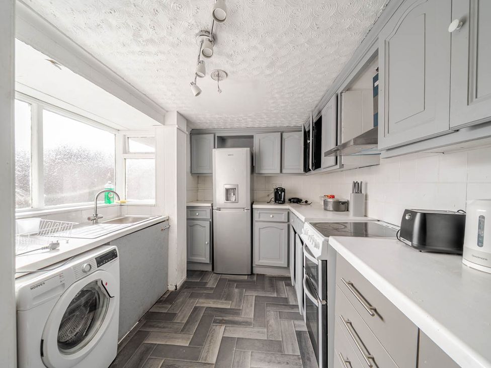 A kitchen with a sink, fridge, washing machine, and kettle at Cosy Hartlepool Home Sleeps 5 Pet Friendly WiFi in Hartlepool