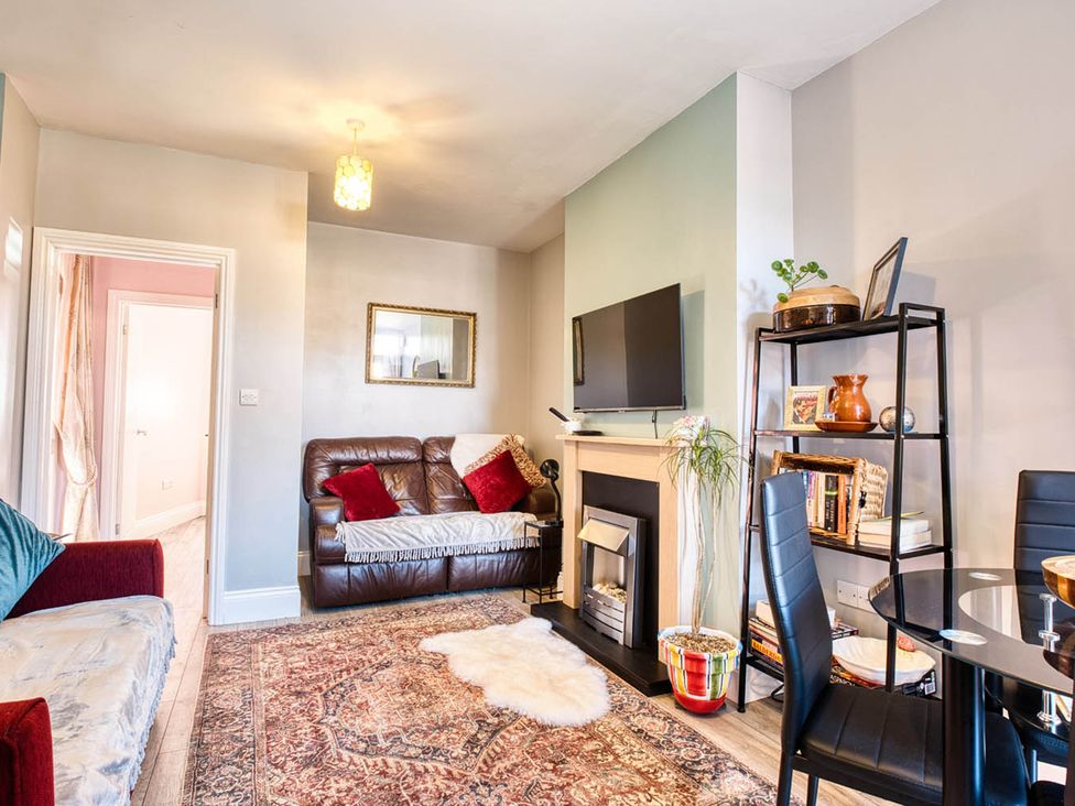 A living room with sofa, television, and dining table at 1bed apartment nr beach with garden Margate
