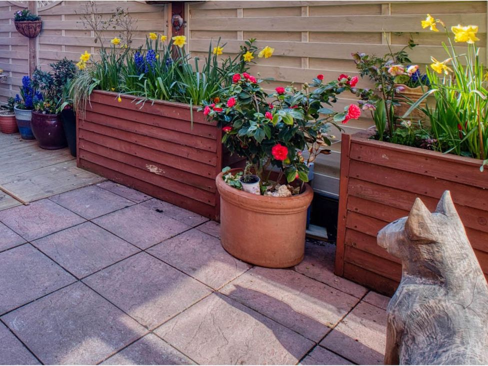A garden with flower pots and a decorative dog statue at 1bed apartment nr beach with garden Margate