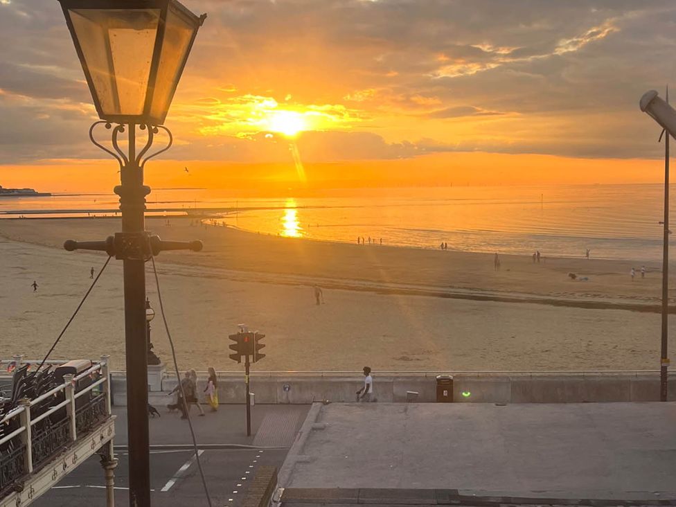 A beach at sunset with people walking at 1bed apartment nr beach with garden Margate