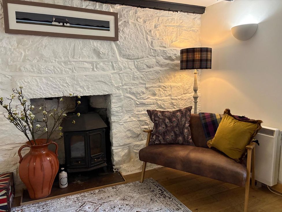 A living room with a sofa and a fireplace at Cosy Cottage Retreat in Edinbane