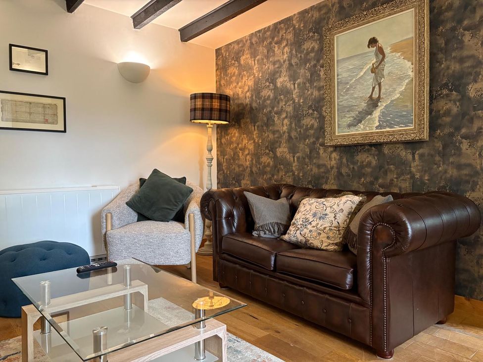 A living room with a sofa and armchair at Cosy Cottage Retreat in Edinbane
